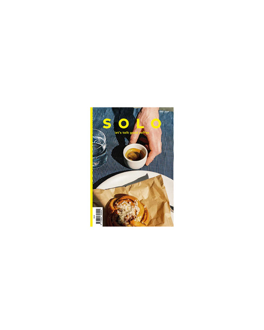 Magazine cover with a hand holding a coffee cup and a plate of food on a white background